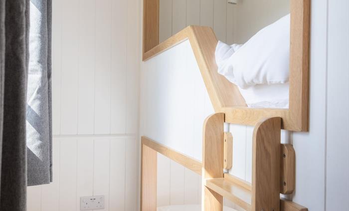 Two small bunk beds with crisp white bed linen